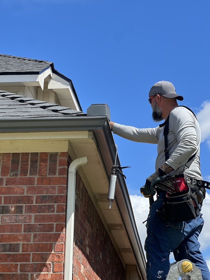 Roofer installing gutter guard on residential roof